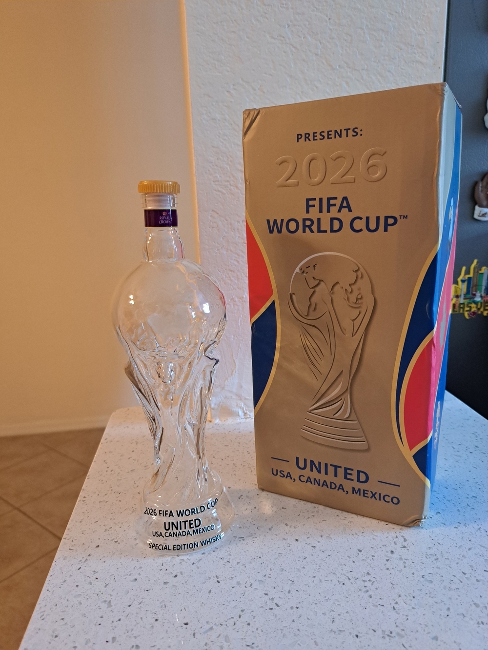 Source Unknown Clear Glass Trophy Bottle with Gold Cap and Blue Label